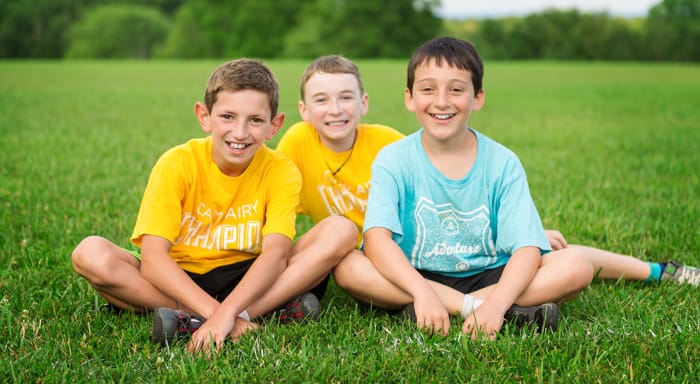 Airy boys sitting on the grass smiling