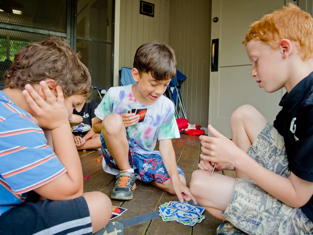 Airy campers playing cards in bunk