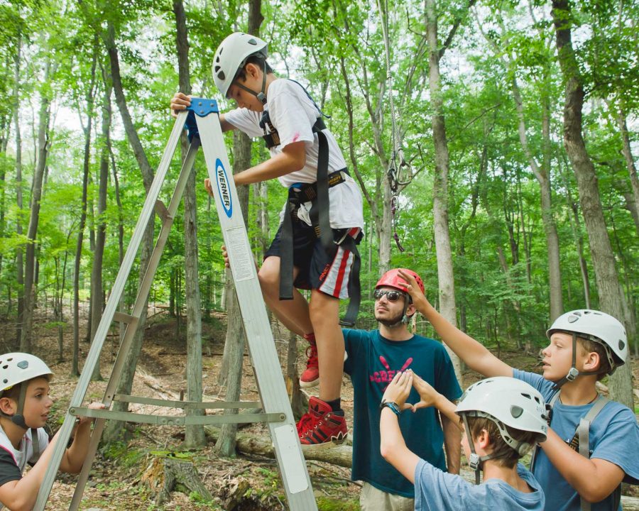 Airy camper climbing up a ladder to high ropes course