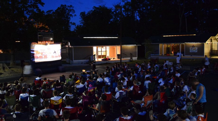 Airy campers watching an outdoor movie