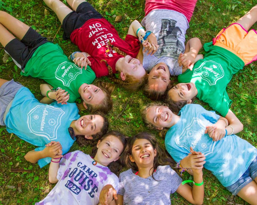 Girls laying on the grass in a circle