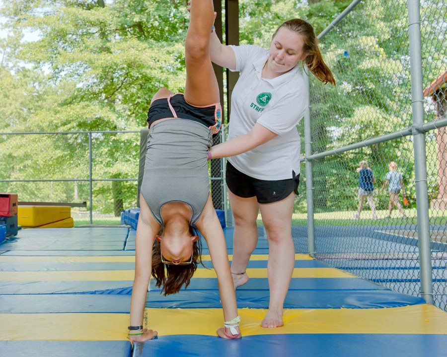 Staff helping camper at gymnastics