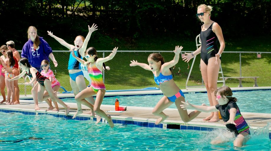 Girls jumping into pool
