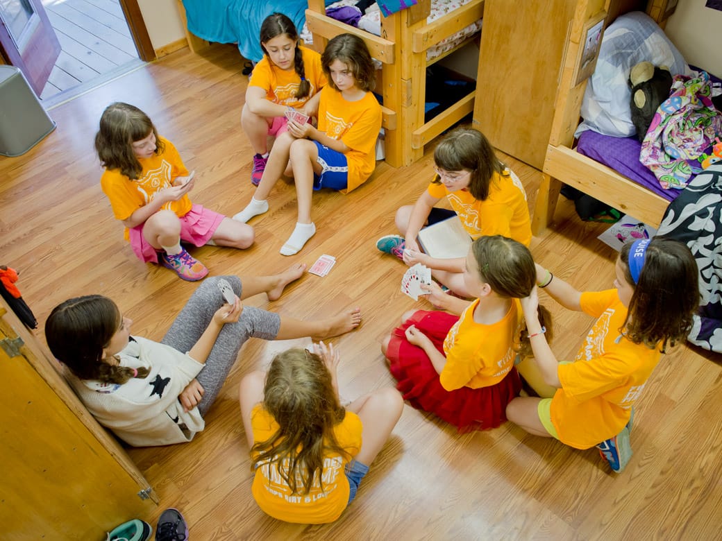 Campers playing cards in bunk