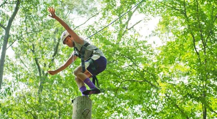 Airy camper on a high ropes course pole