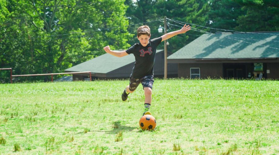 Camper kicking a soccer ball