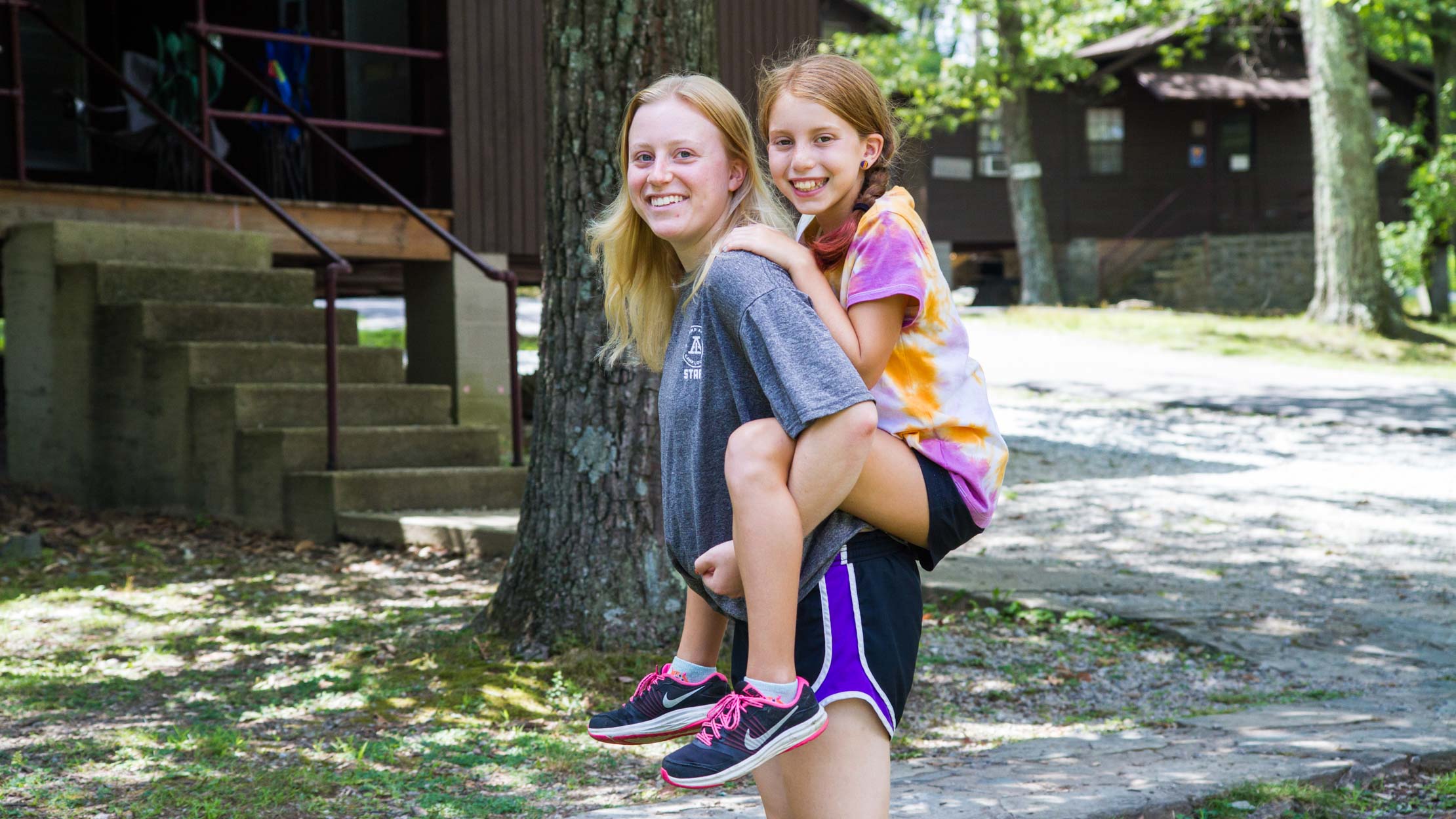 Camper and staff piggyback