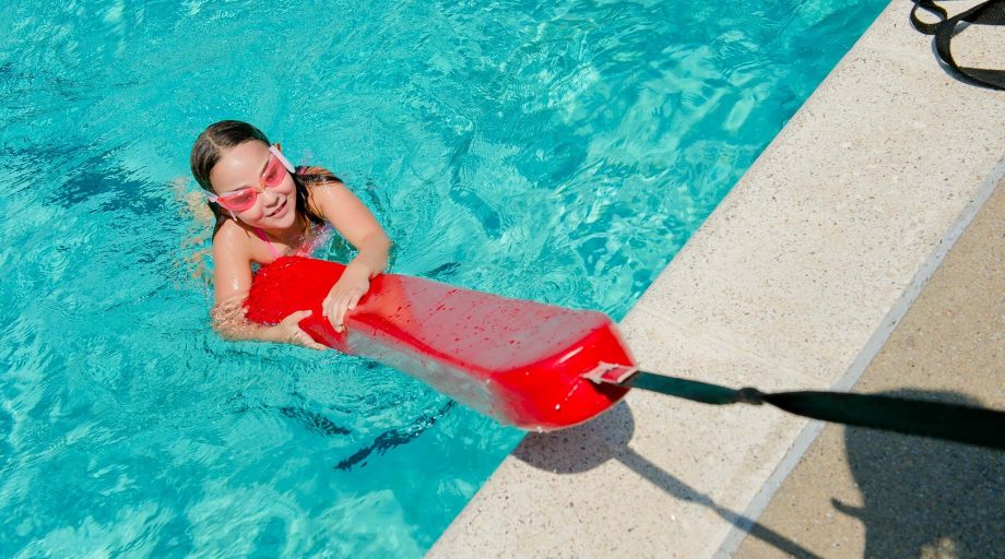 Girl holding onto lifeguard floatation device